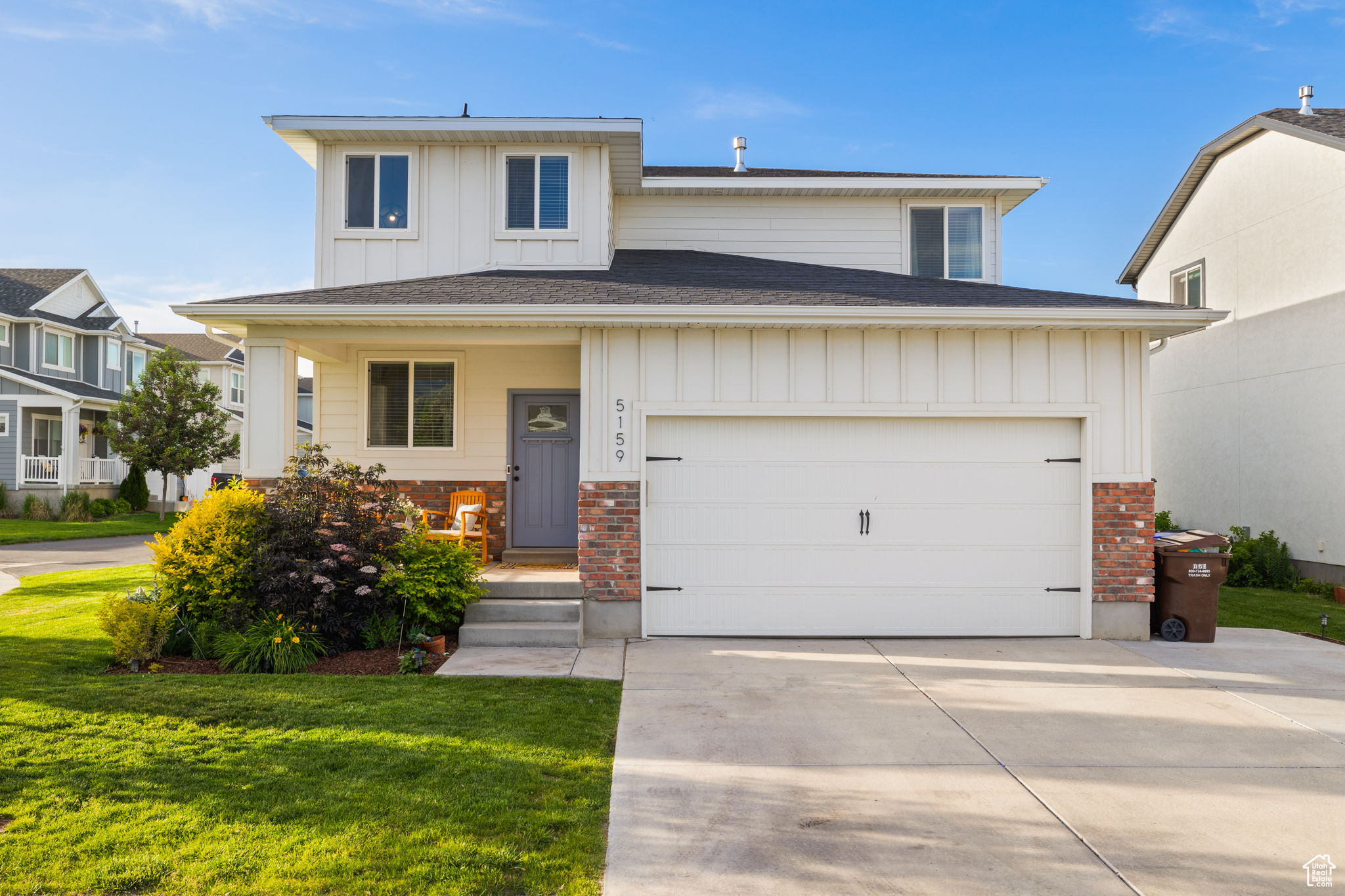 View of front of property featuring a garage and a front lawn