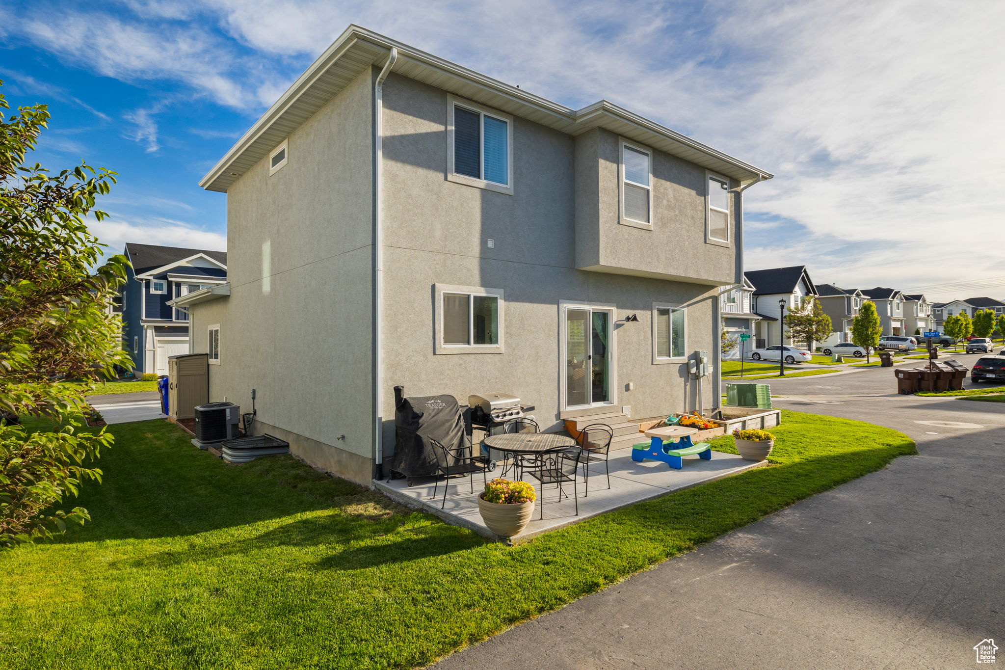 Rear view of property with a patio area, central AC unit, and a yard