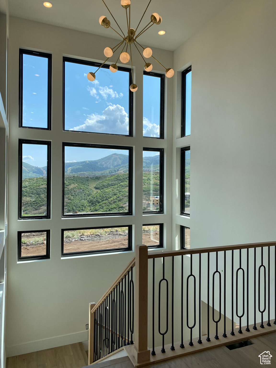 Stairway featuring a wealth of natural light, a mountain view, a notable chandelier, and hardwood / wood-style floors