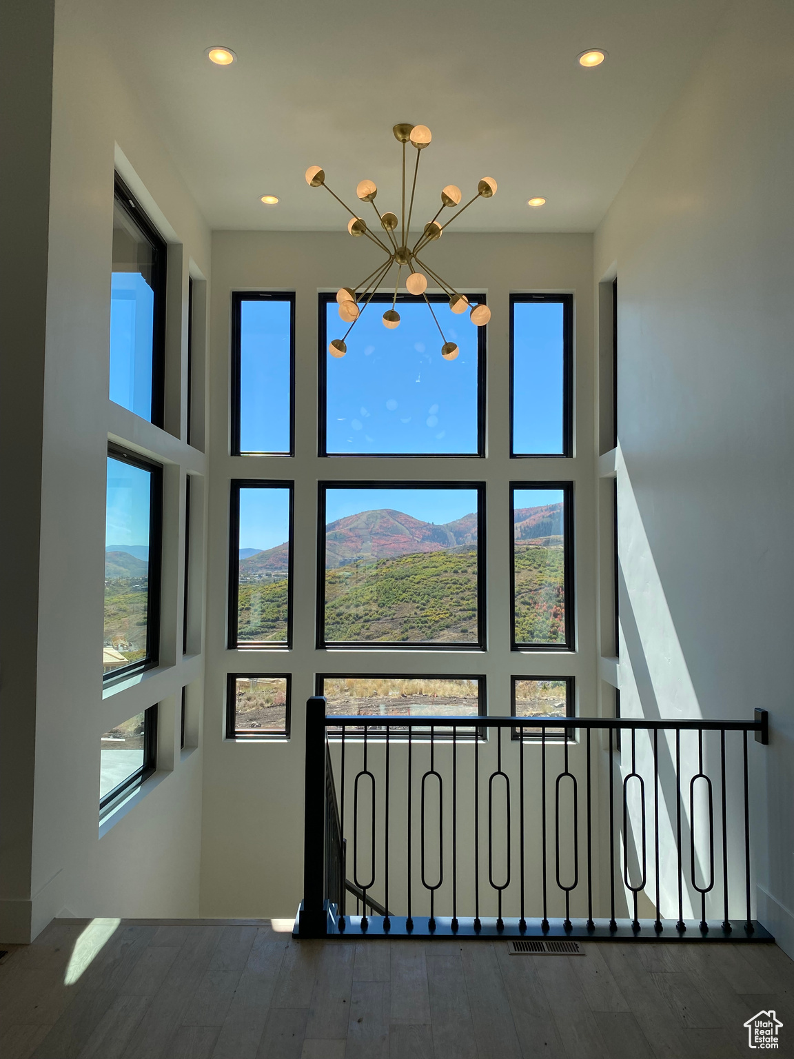 Stairway with wood-type flooring, a mountain view, and a notable chandelier