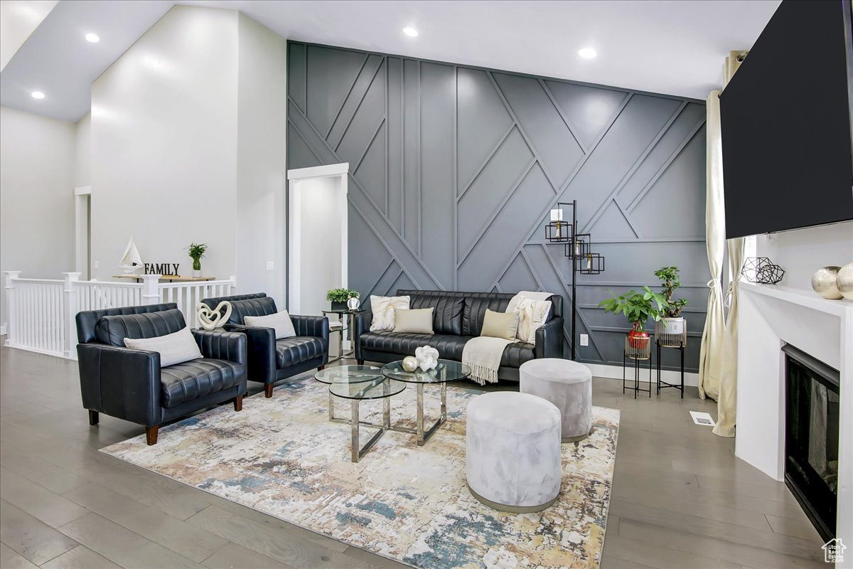 Living room with a high ceiling and wood-type flooring