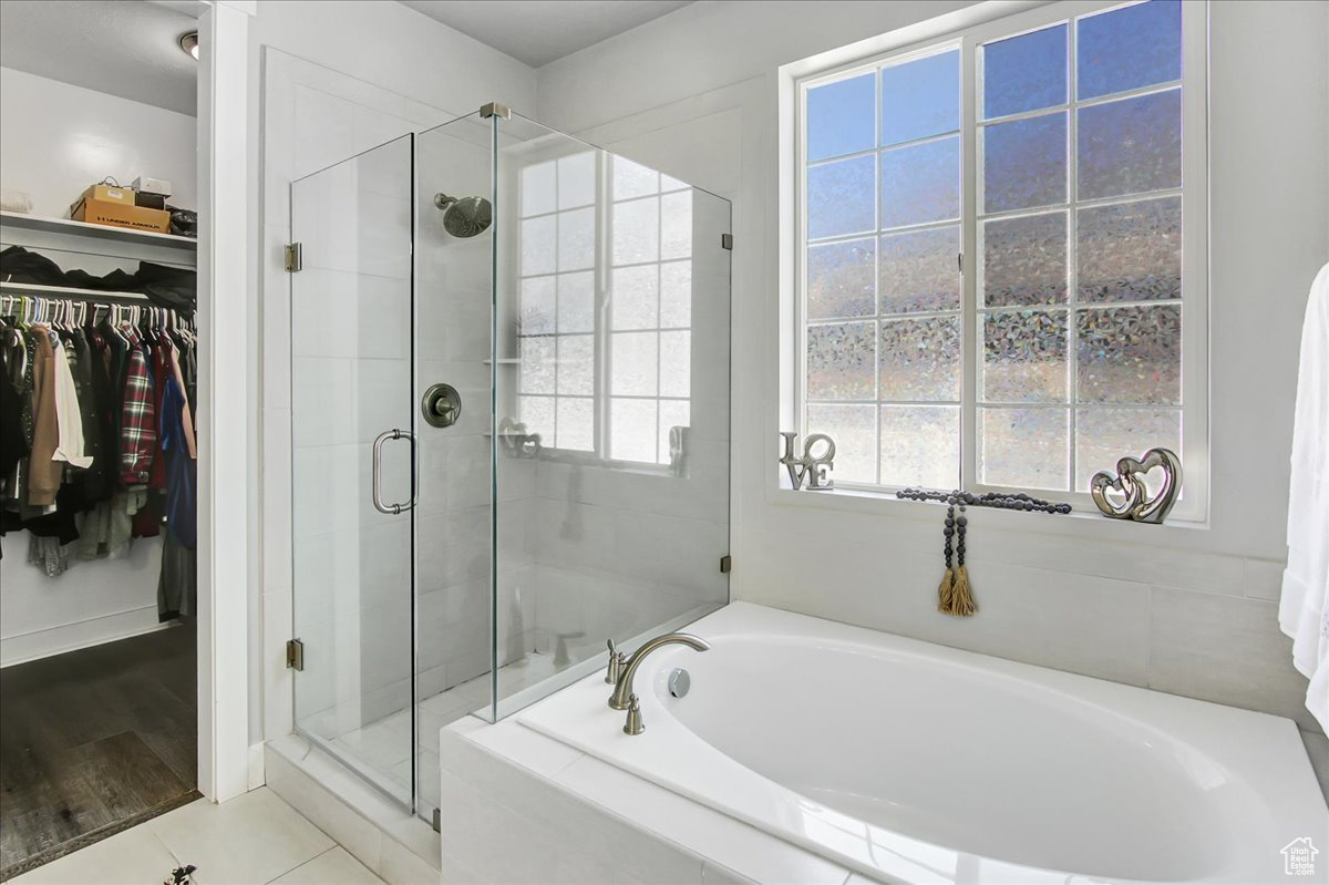 Bathroom with tile flooring, separate shower and tub, and plenty of natural light