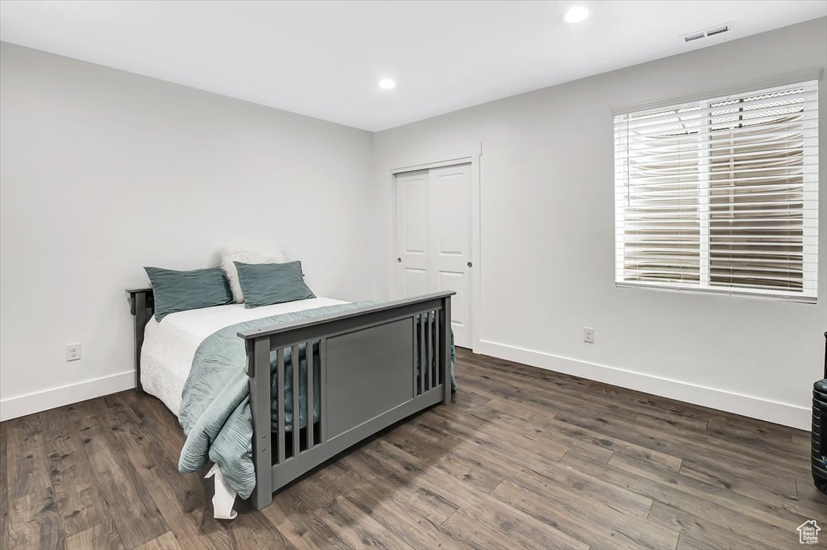 Bedroom featuring a closet and dark hardwood / wood-style flooring