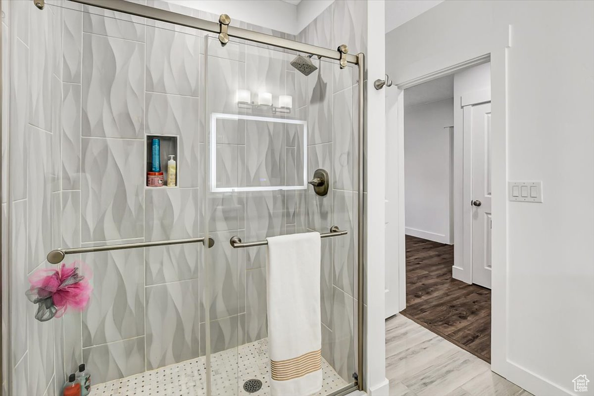 Bathroom featuring walk in shower and hardwood / wood-style floors