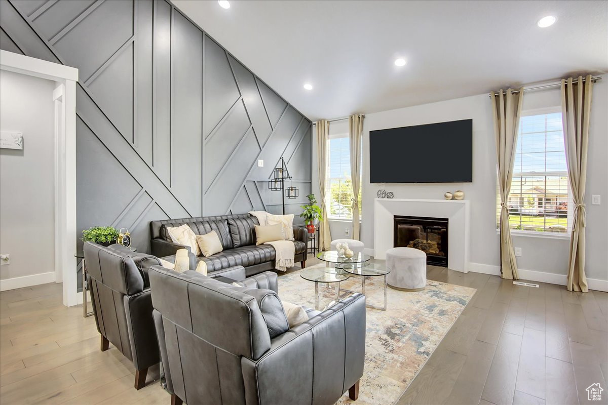 Living room with light hardwood / wood-style flooring and lofted ceiling