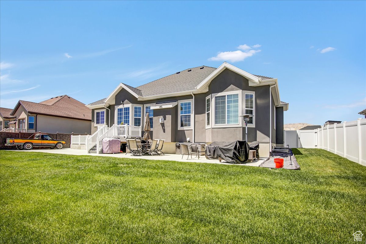 Rear view of house featuring a patio and a yard