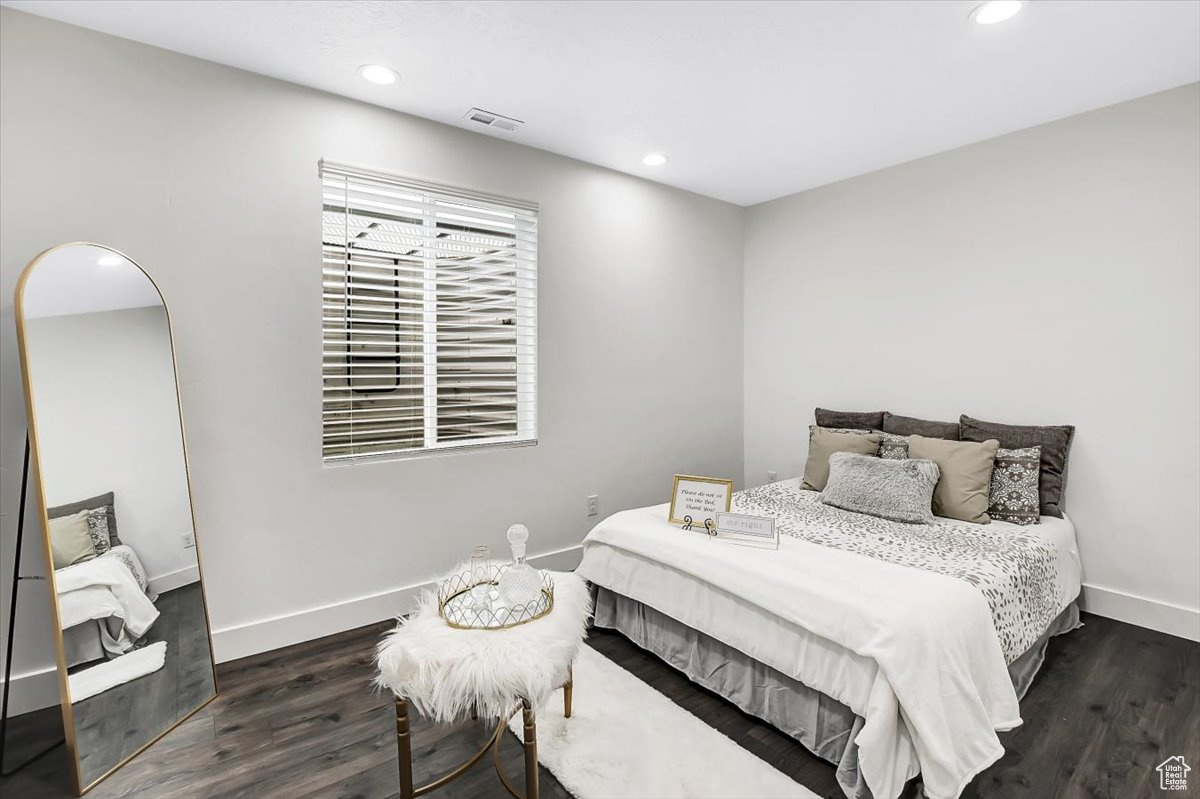 Bedroom with dark hardwood / wood-style floors