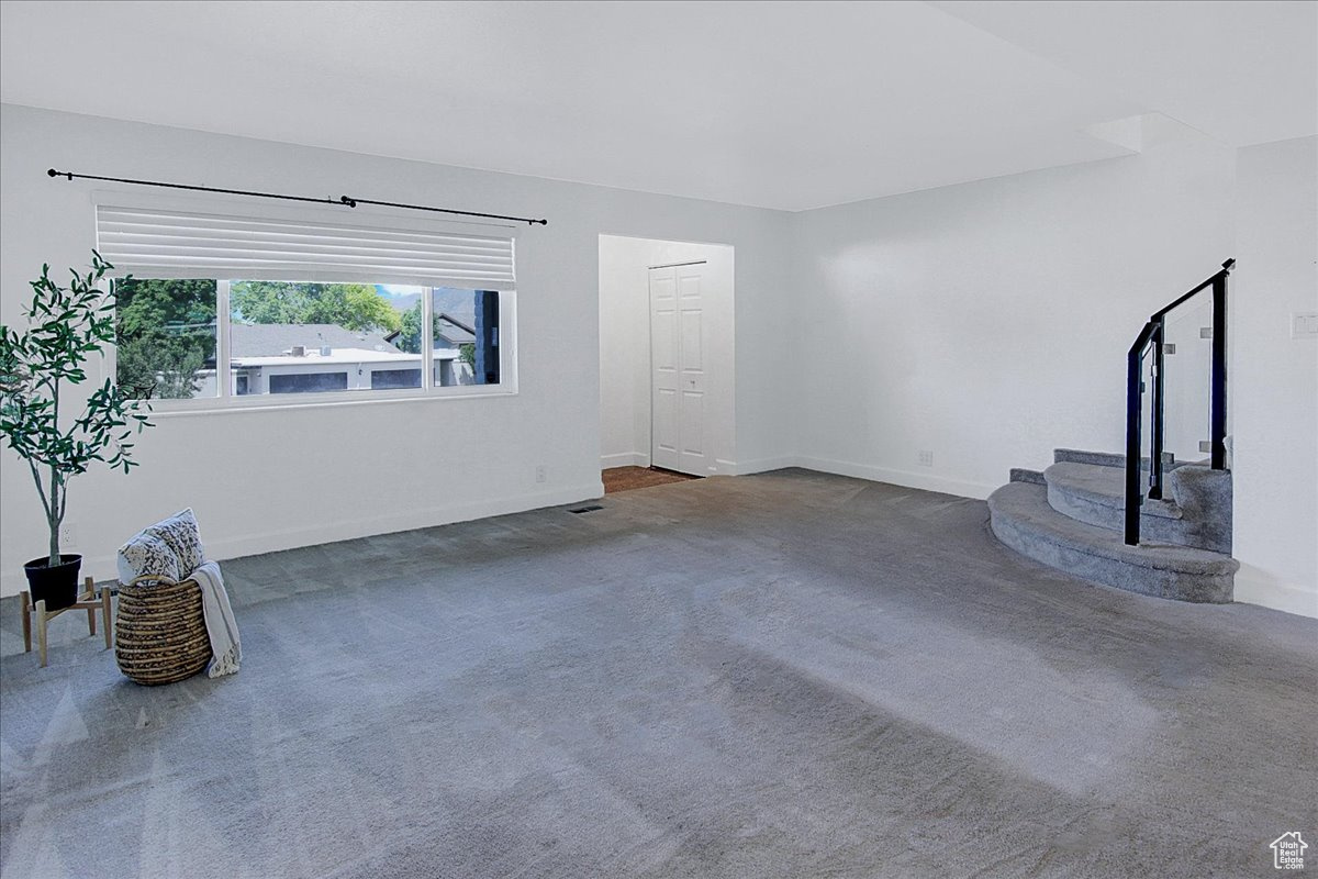 Unfurnished living room with dark colored carpet