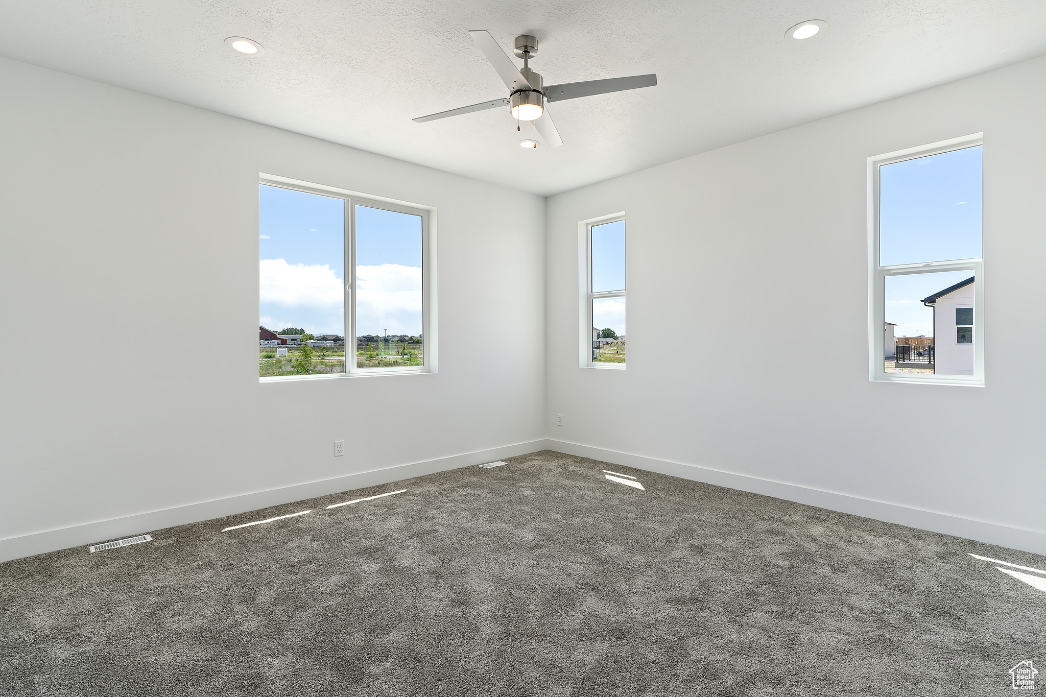 Empty room featuring carpet and ceiling fan