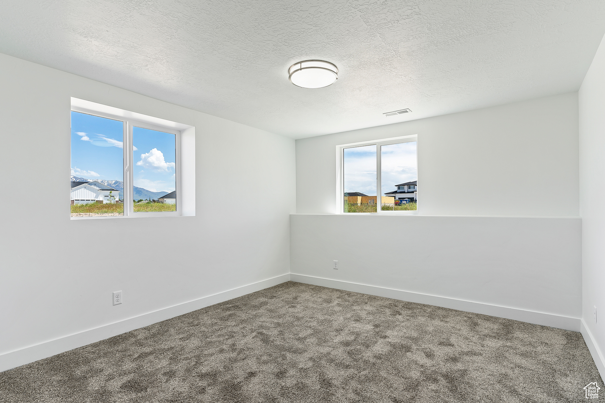 Unfurnished room with a textured ceiling and carpet floors