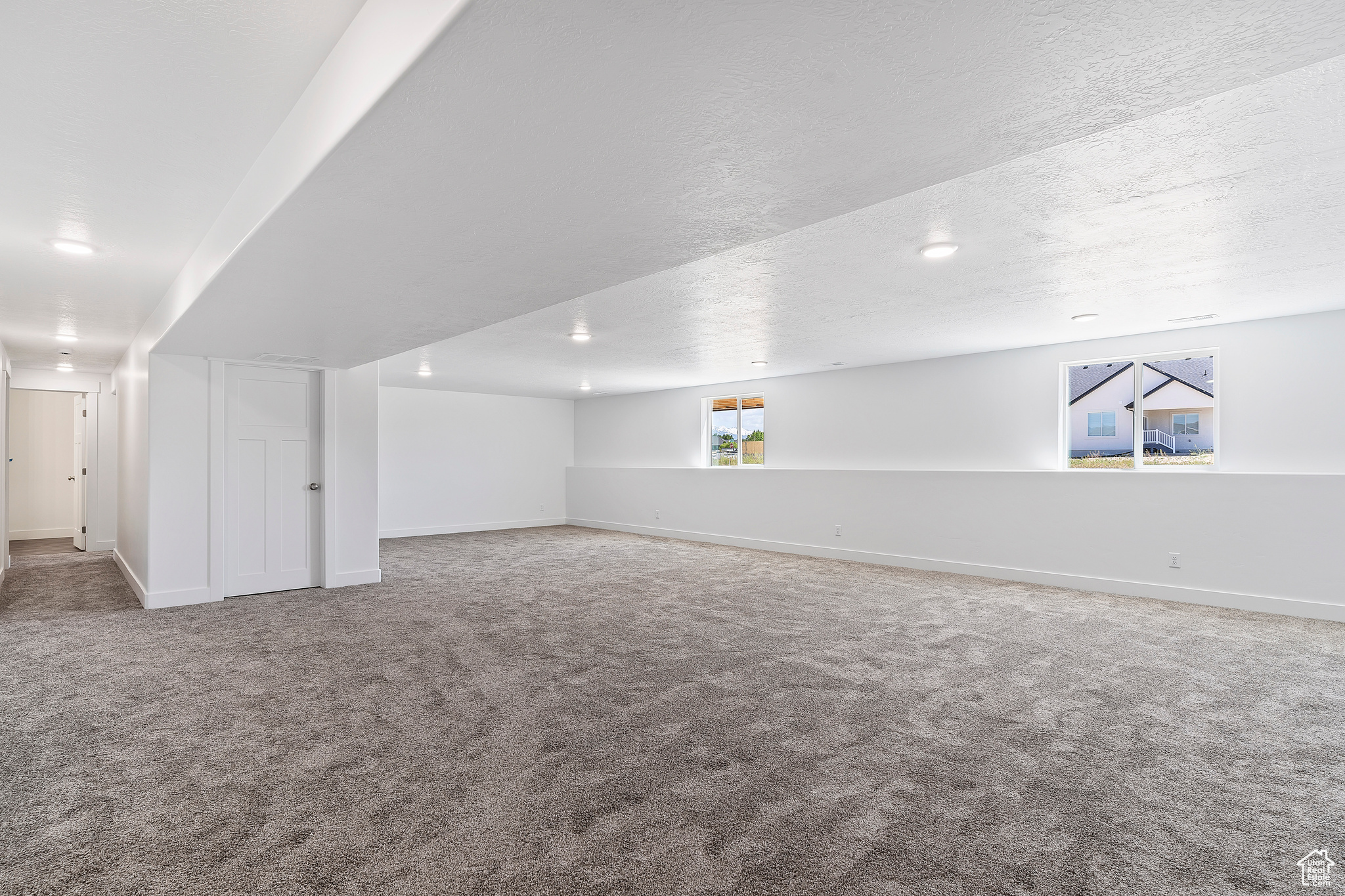 Bonus room featuring a textured ceiling, a healthy amount of sunlight, and carpet floors