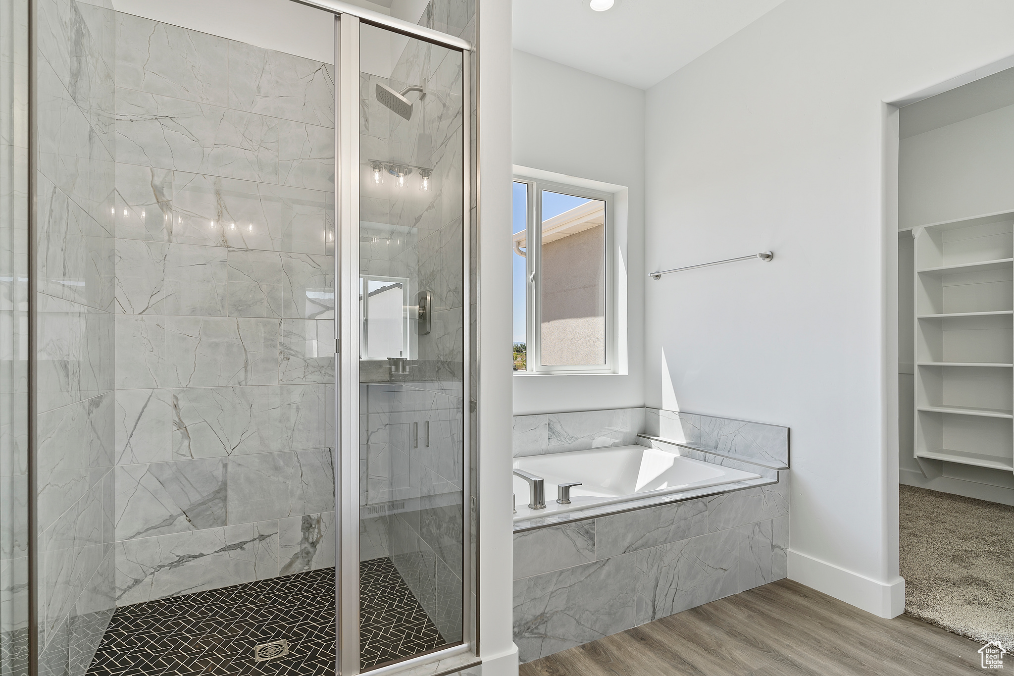 Bathroom featuring wood-type flooring and separate shower and tub