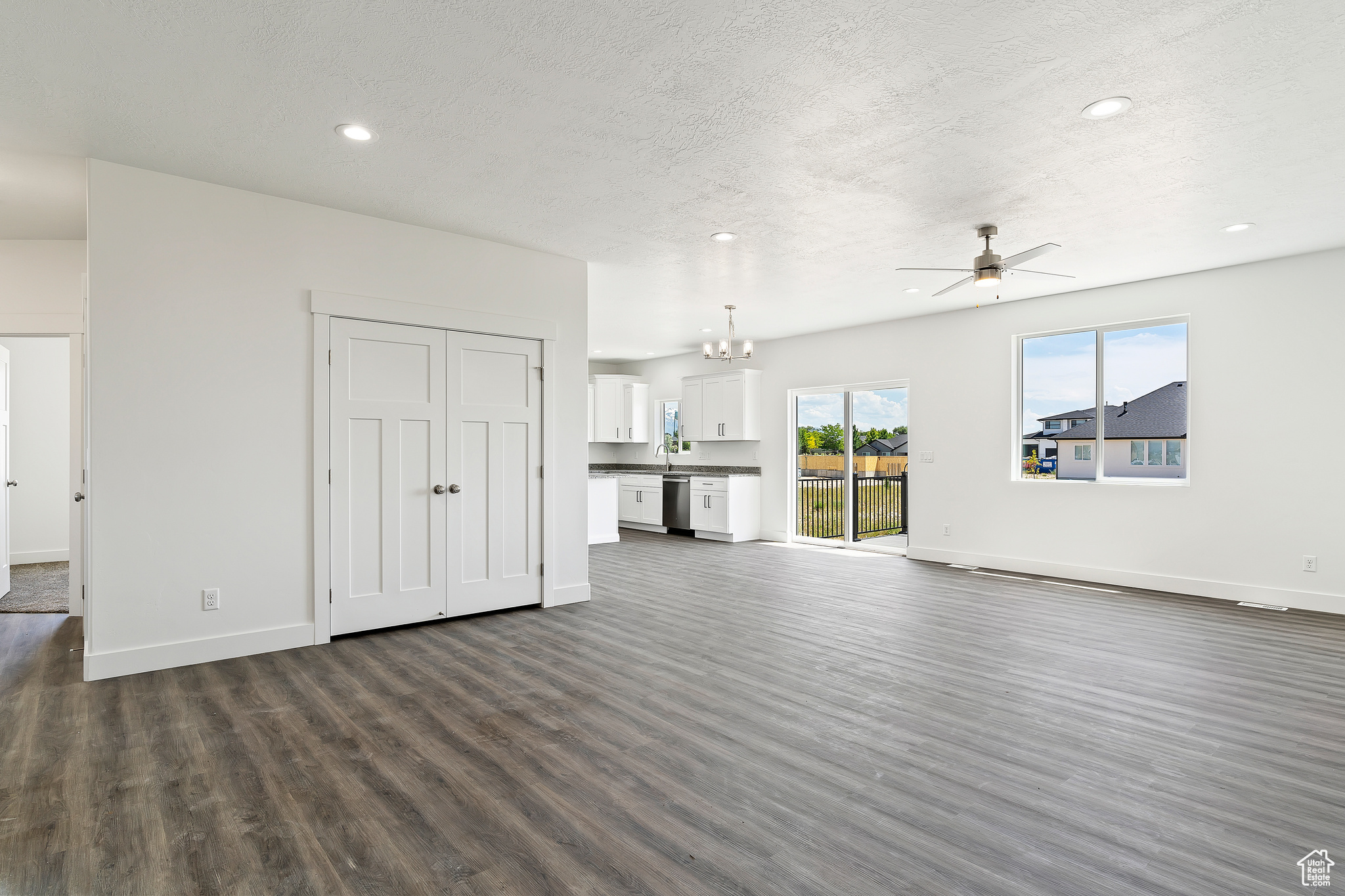 Unfurnished living room with ceiling fan and dark hardwood / wood-style floors