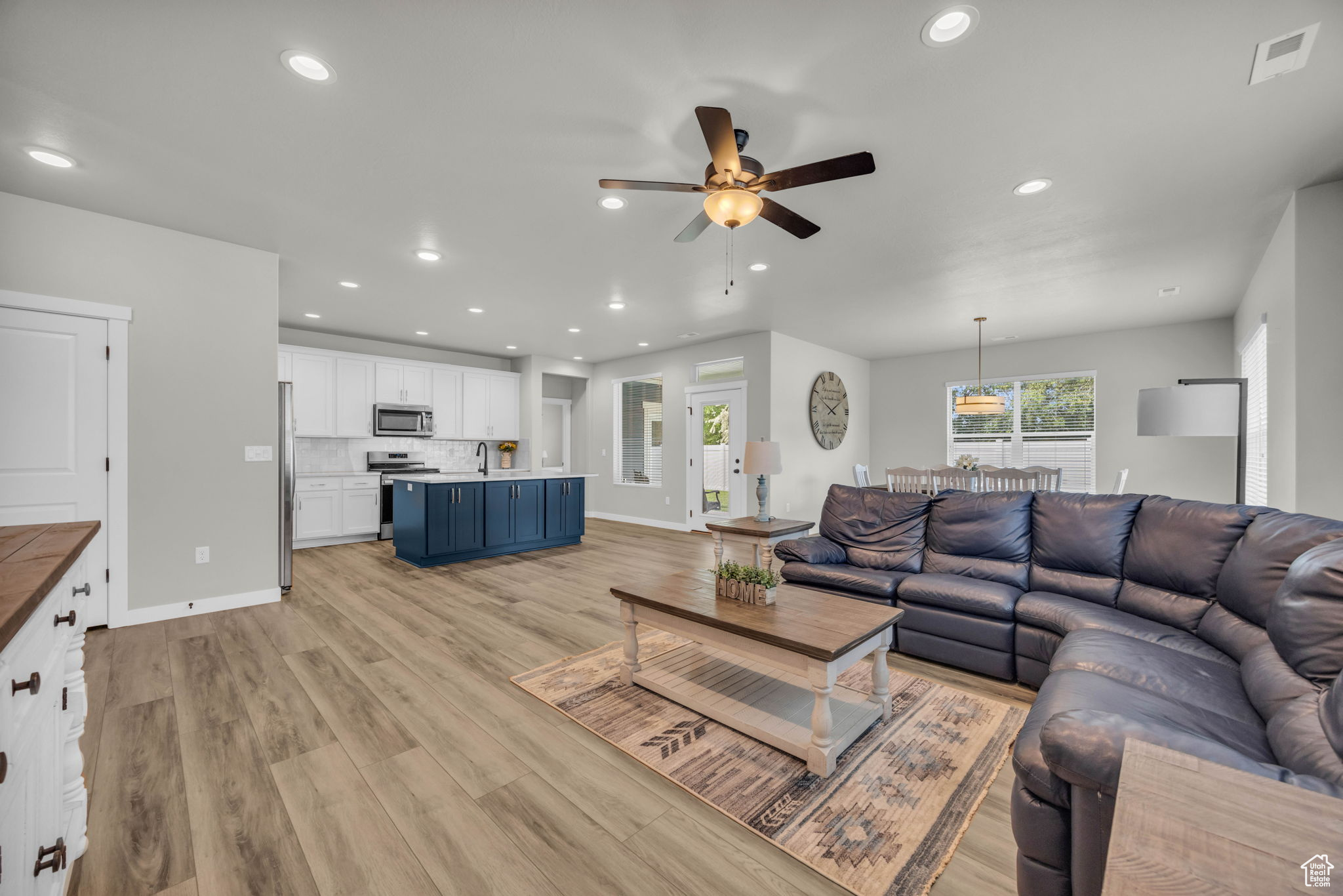 Living room featuring ceiling fan, sink, and light hardwood / wood-style floors