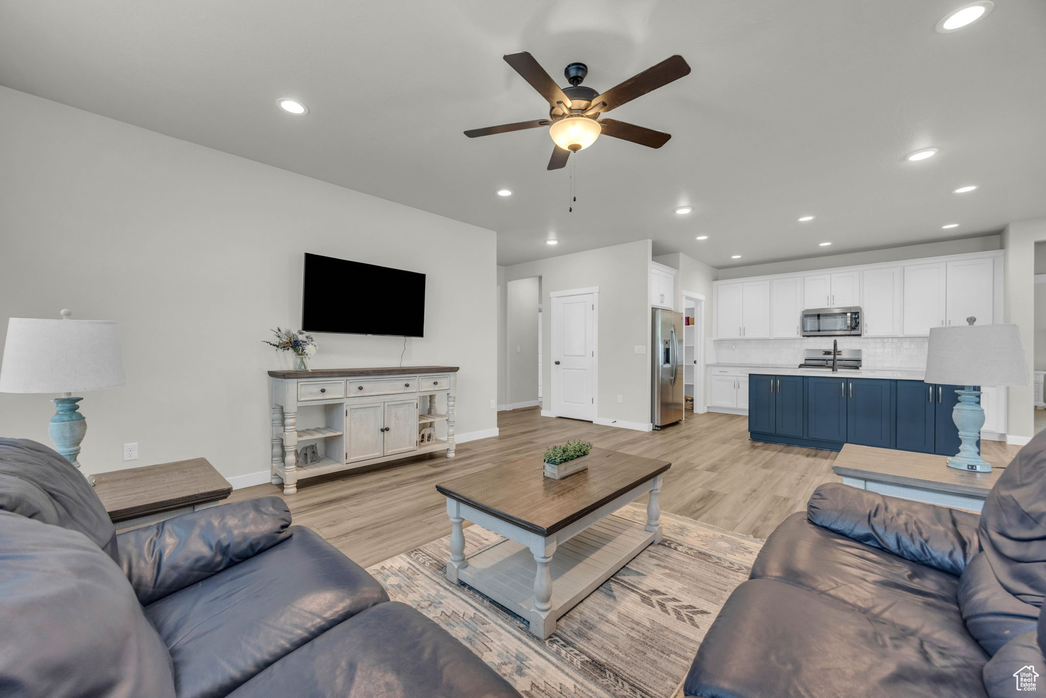 Living room with light hardwood / wood-style floors and ceiling fan