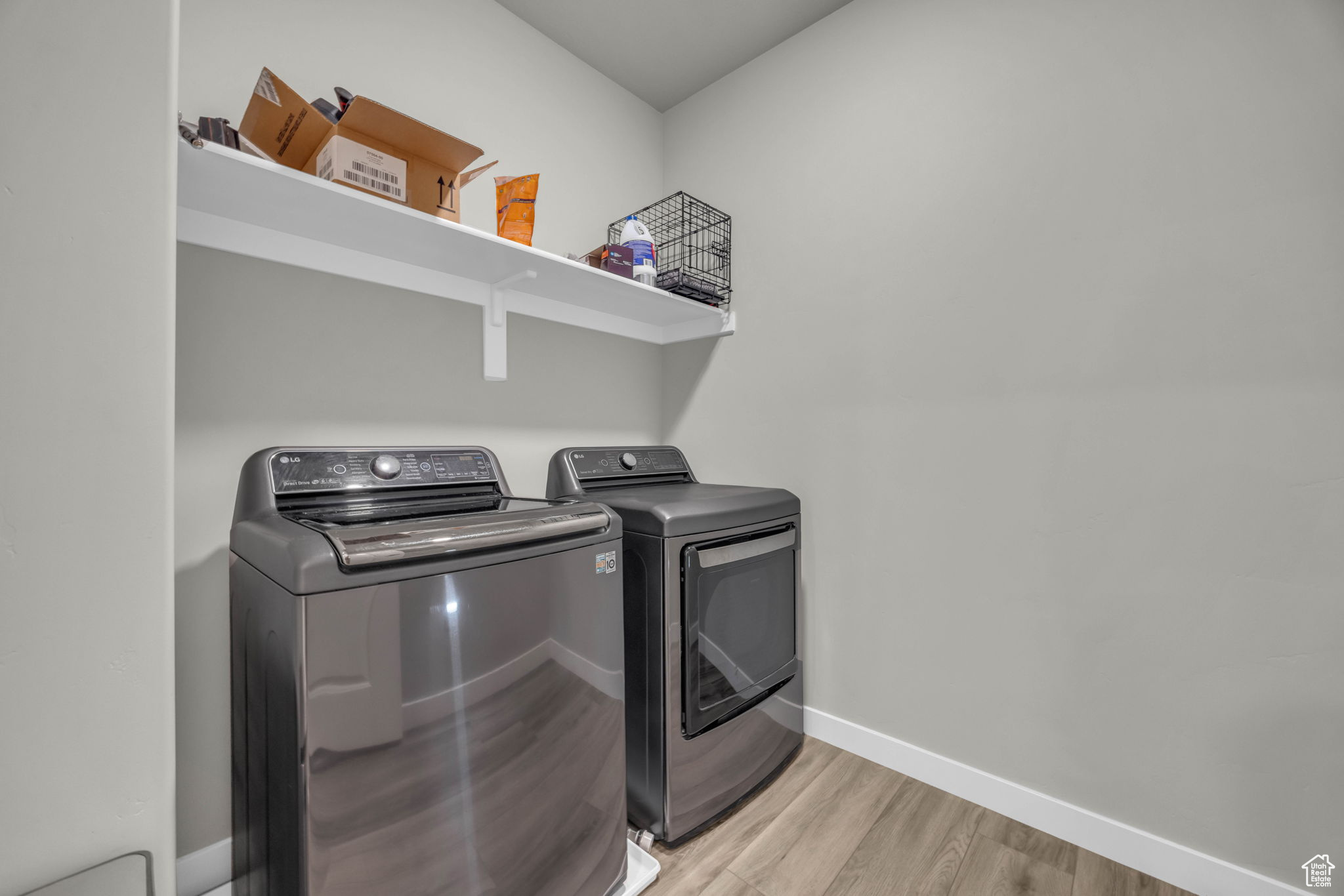 Washroom featuring light hardwood / wood-style floors and washing machine and clothes dryer