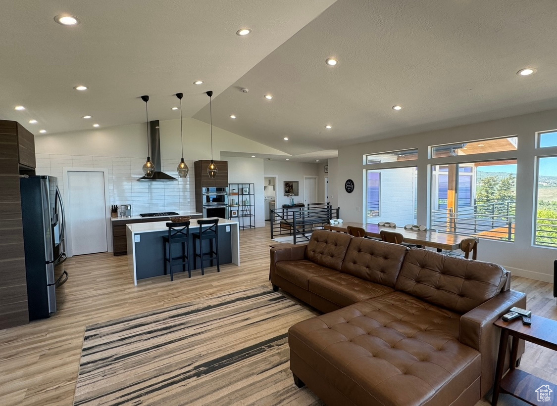 Living room featuring light wood-type flooring and lofted ceiling