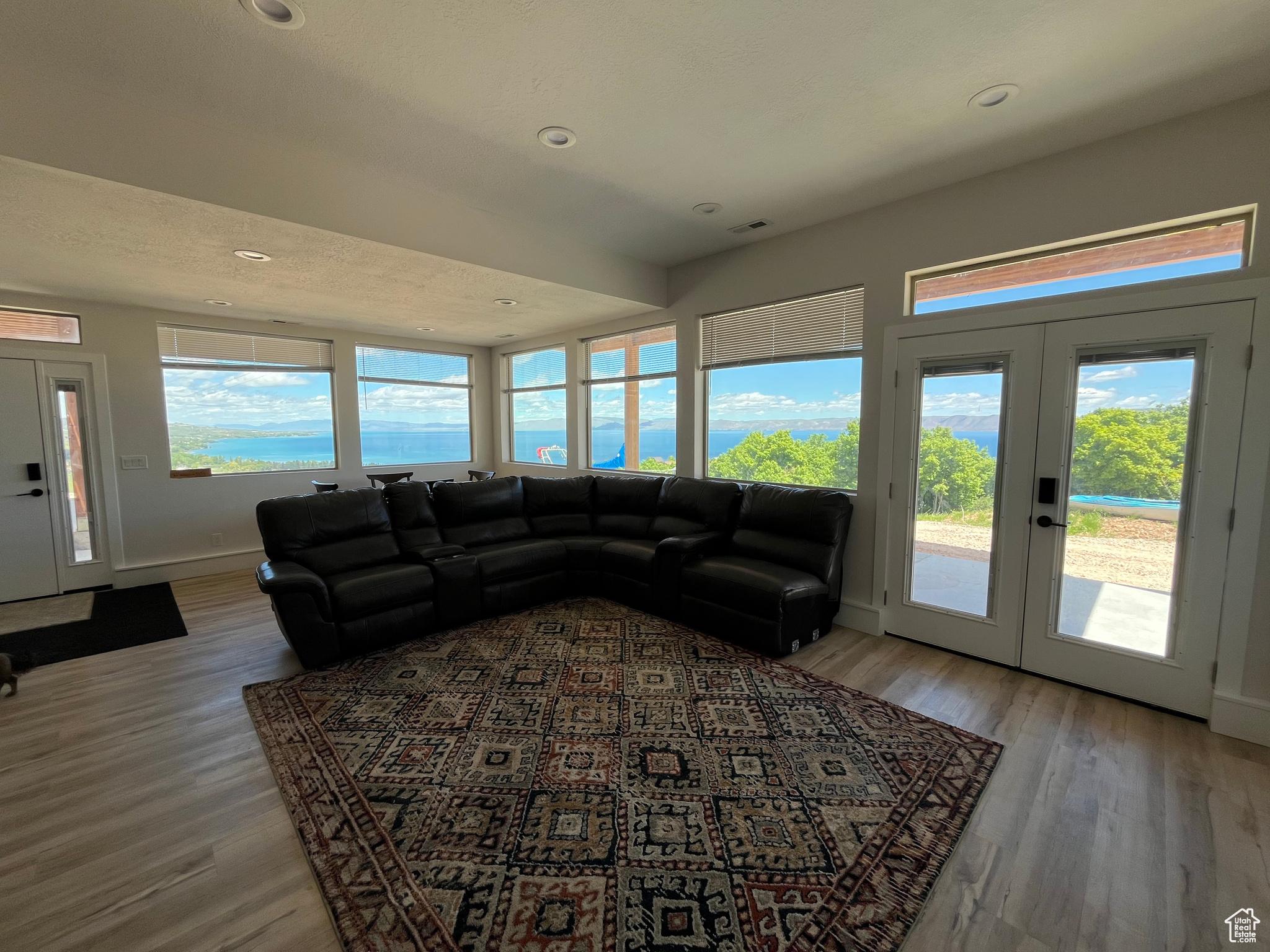 Lower level Living room with plenty of natural light, french doors, and hardwood / wood-style floors