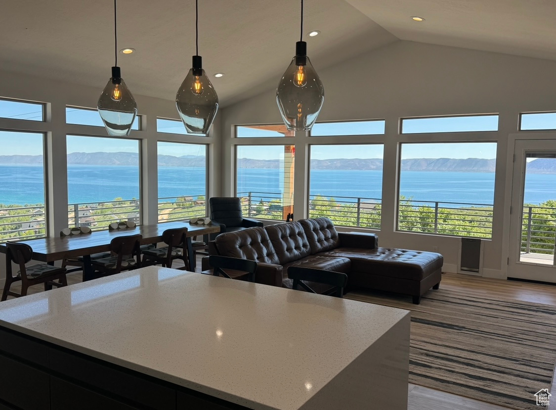 Kitchen featuring high vaulted ceiling, a center island, a water and mountain view, and pendant lighting