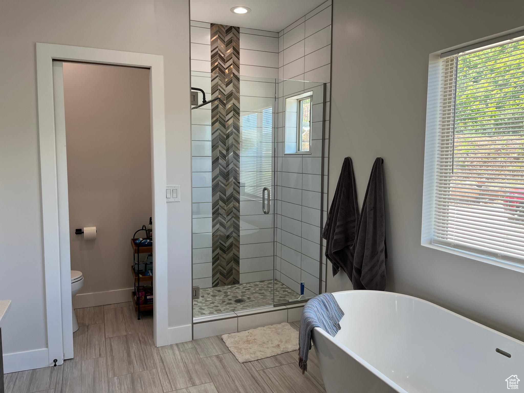 Master Bathroom featuring toilet, tile floors, and plus walk in shower