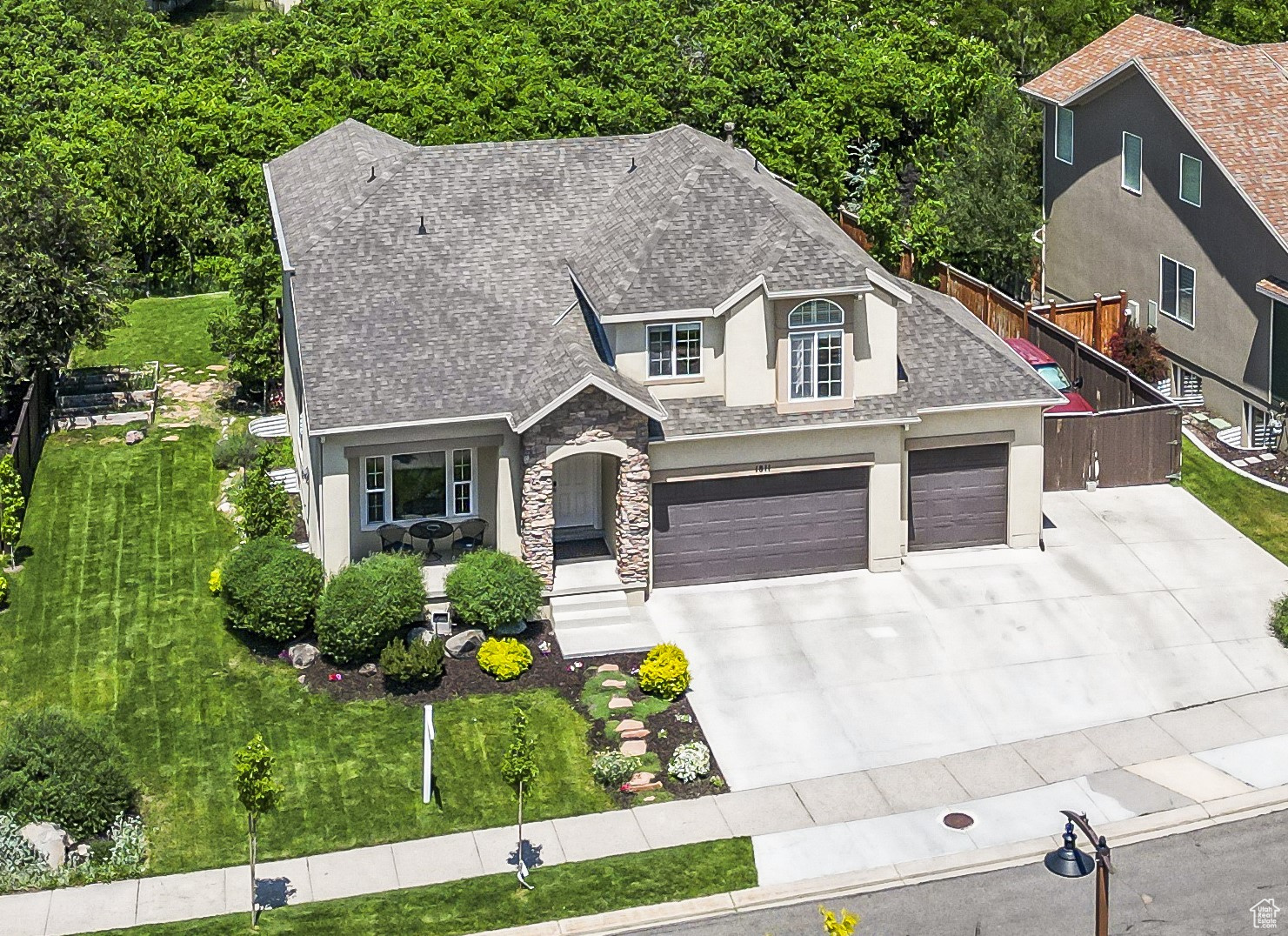 View of front of home with a garage + front lawn + Oversized Driveway. Front door faces South