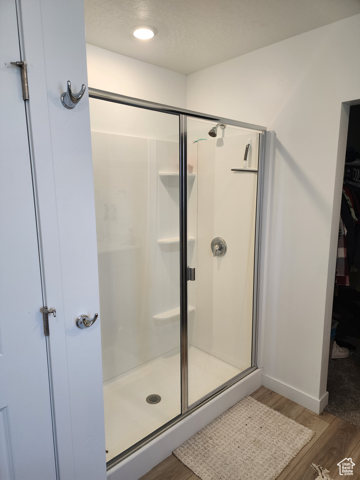 Bathroom featuring wood-type flooring and an enclosed shower