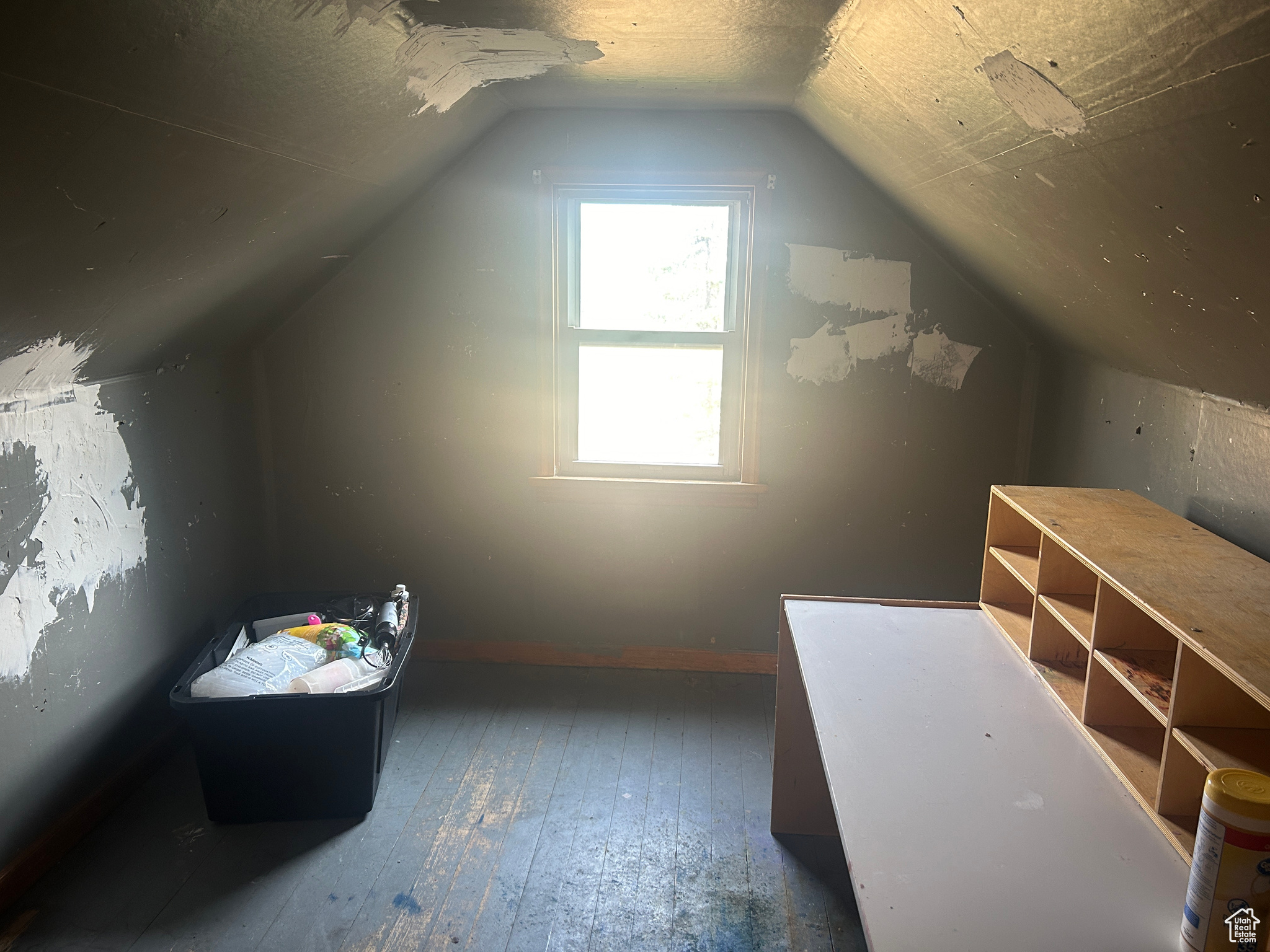 Bonus room with a textured ceiling, hardwood / wood-style flooring, and vaulted ceiling