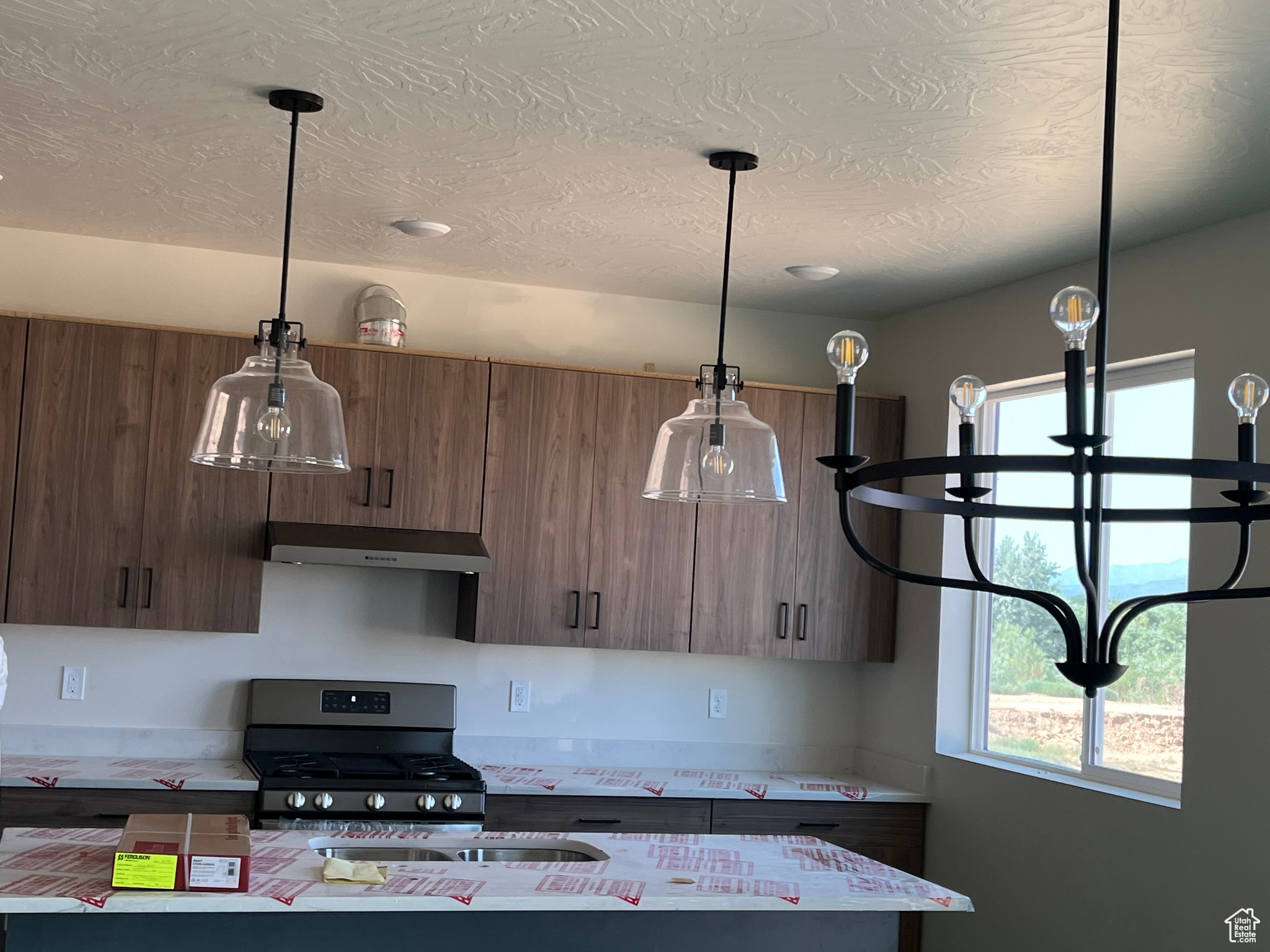 Kitchen with pendant lighting and stainless steel gas range oven