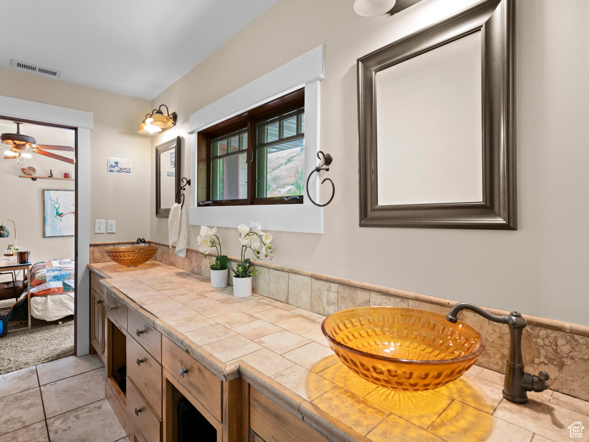 Bathroom featuring tile floors, large vanity, ceiling fan, and dual sinks