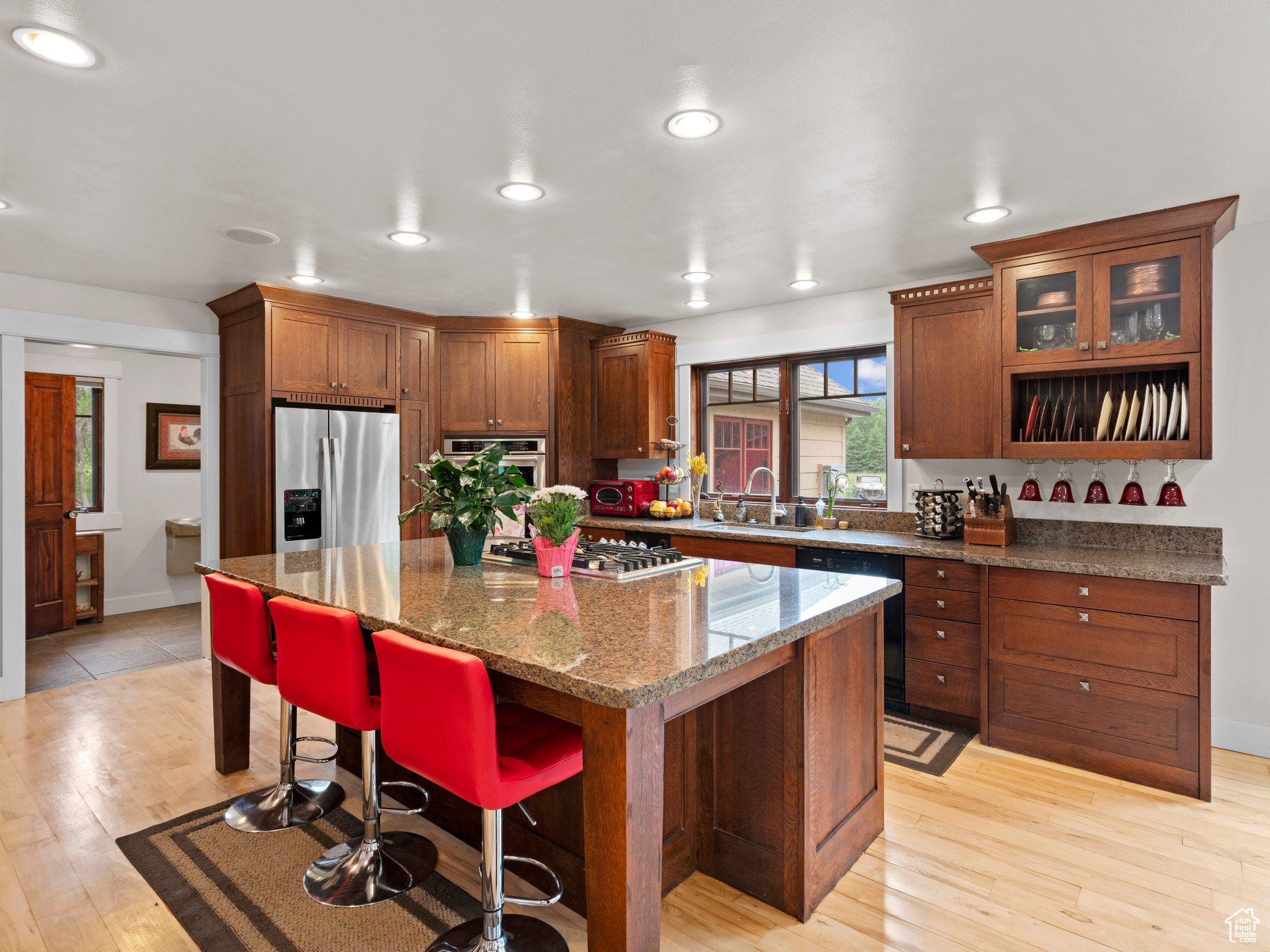 Kitchen featuring stainless steel appliances, a center island, granite counters, and hardwood floors