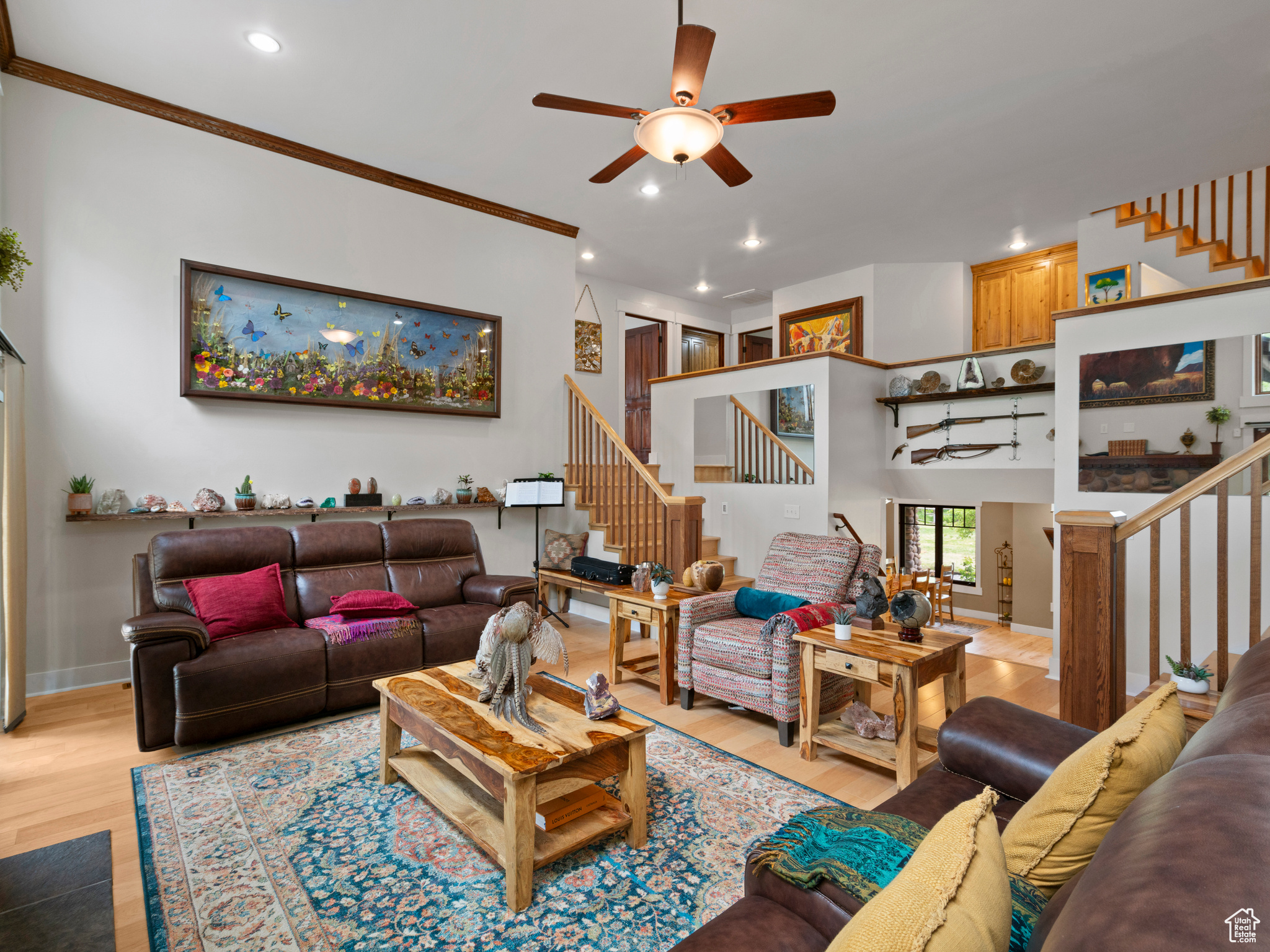 Living room featuring ceiling fan, hardwood flooring, and ornamental molding