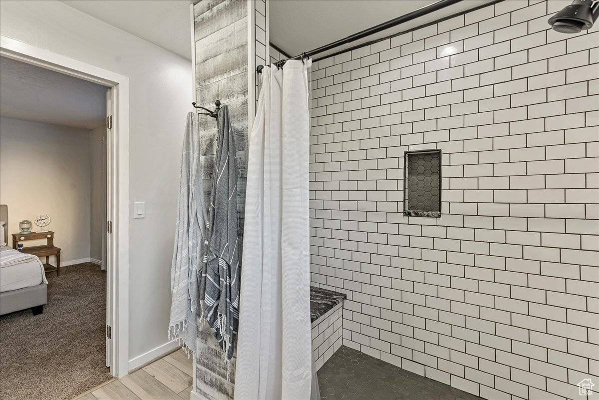 Bathroom with a shower with shower curtain and wood-type flooring