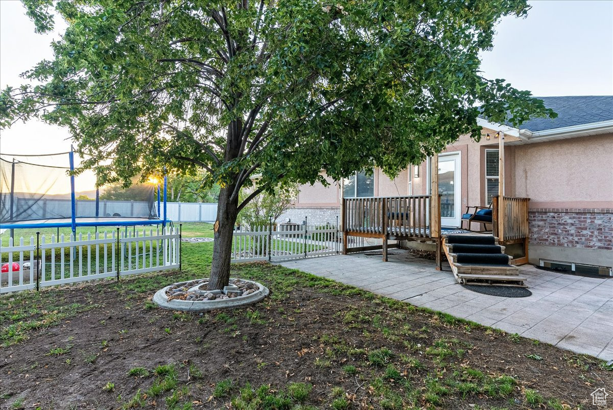 View of yard featuring a trampoline and a patio area