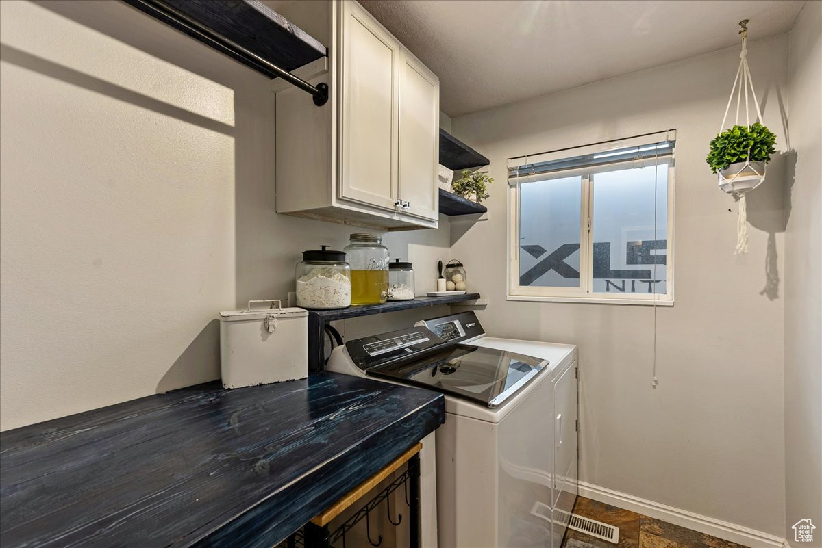 Laundry area featuring cabinets and washing machine and dryer