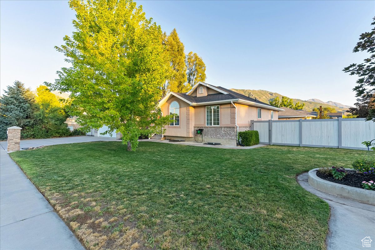 View of front of property featuring a mountain view and a front lawn