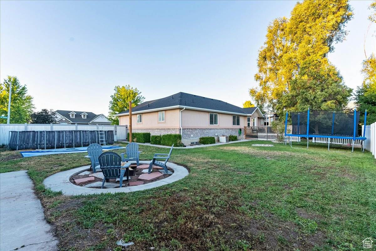 View of yard featuring a trampoline and a patio area