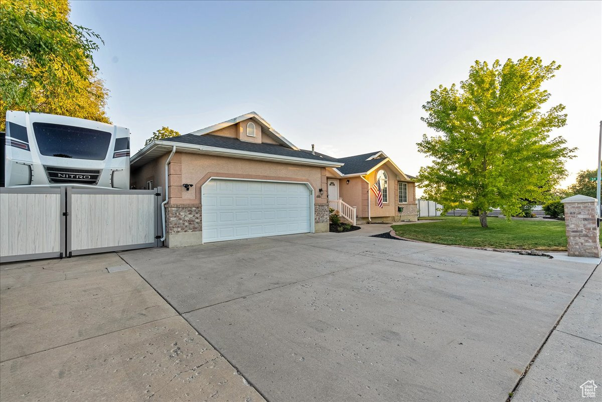 Ranch-style house with a garage and a front lawn