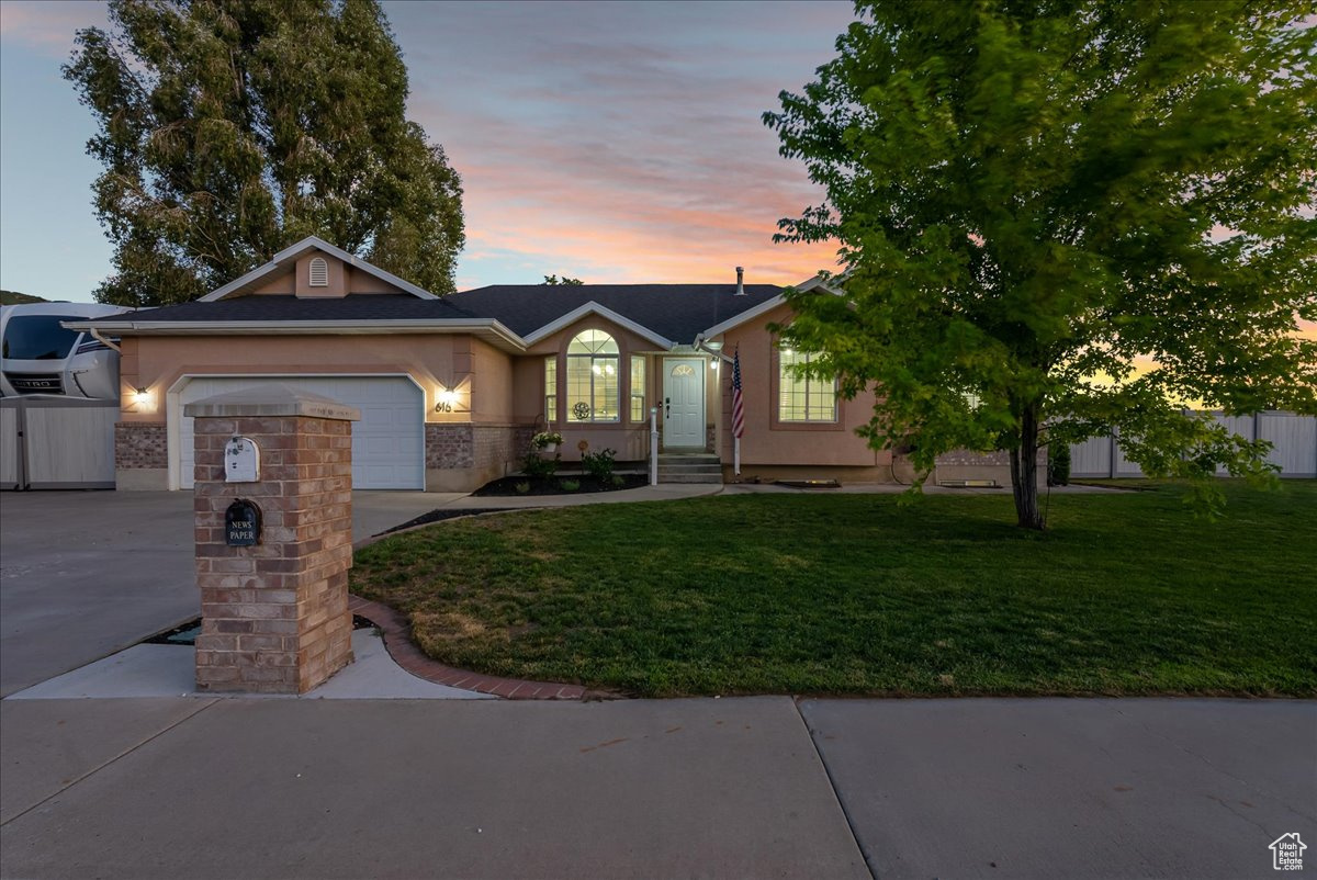 Ranch-style house with a garage and a yard