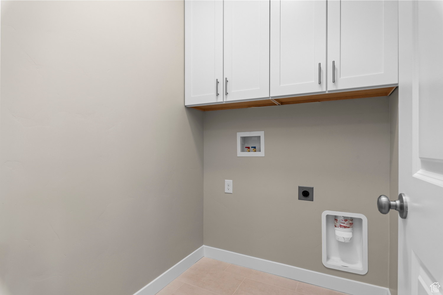 Washroom featuring cabinets, hookup for an electric dryer, light tile floors, and washer hookup