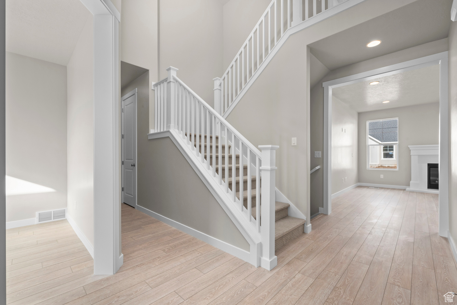 Staircase with light hardwood / wood-style flooring