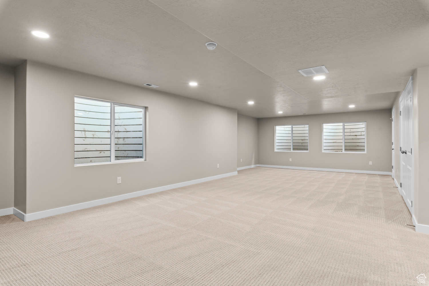 Empty room featuring light carpet and a textured ceiling