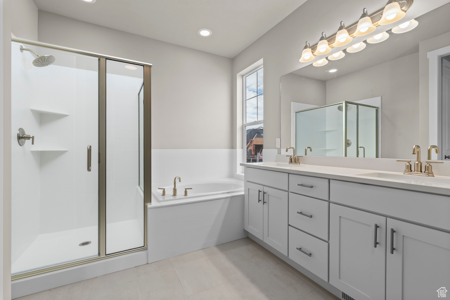 Bathroom with tile floors, shower with separate bathtub, and double vanity