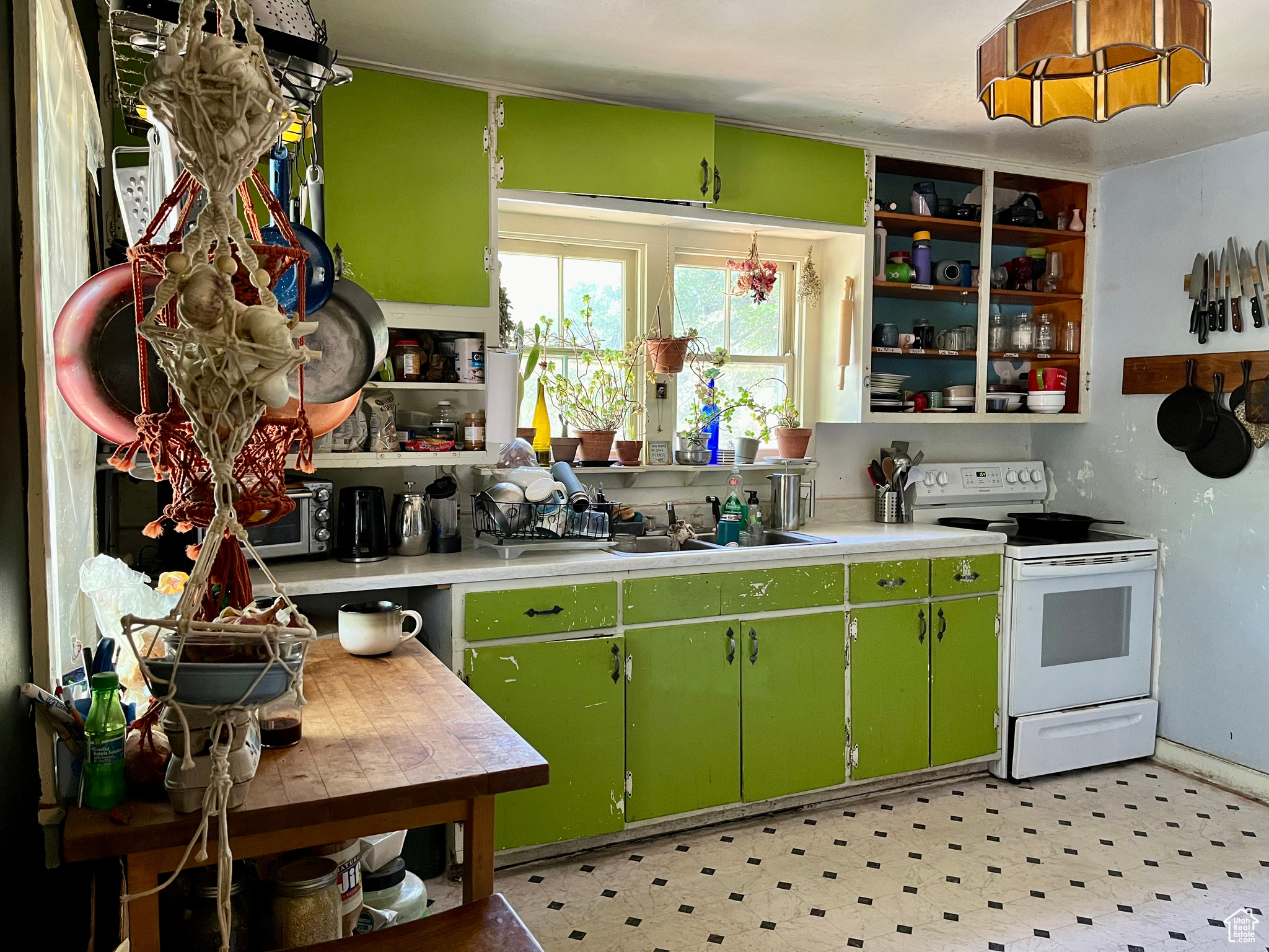 Kitchen featuring sink, electric range, and green cabinets