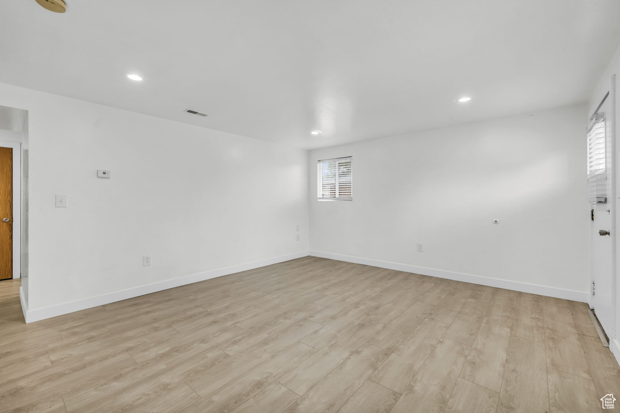 Empty room with light hardwood / wood-style flooring