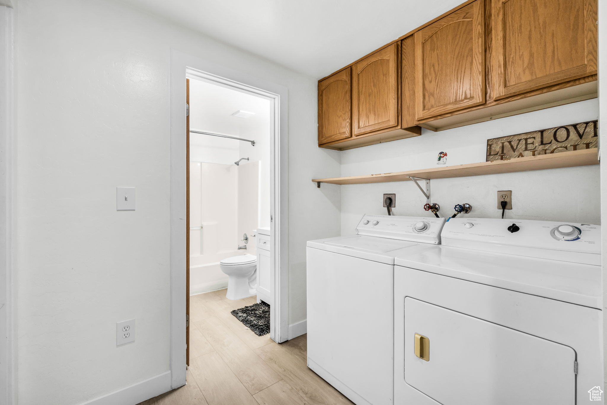 Laundry room with light hardwood / wood-style floors, cabinets, hookup for an electric dryer, hookup for a washing machine, and independent washer and dryer