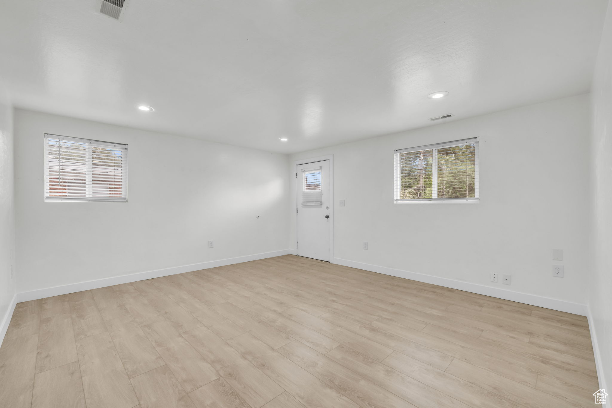 Empty room with light hardwood / wood-style floors