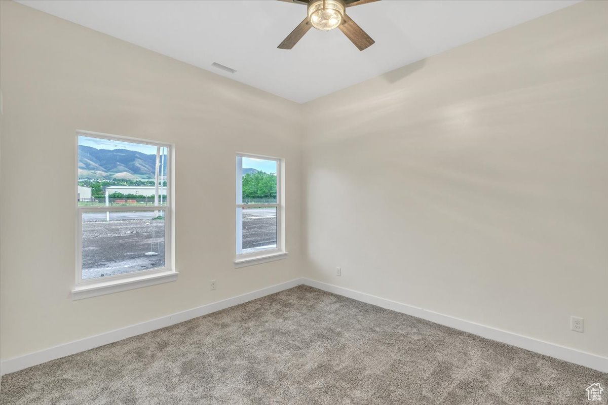 Empty room featuring carpet and ceiling fan