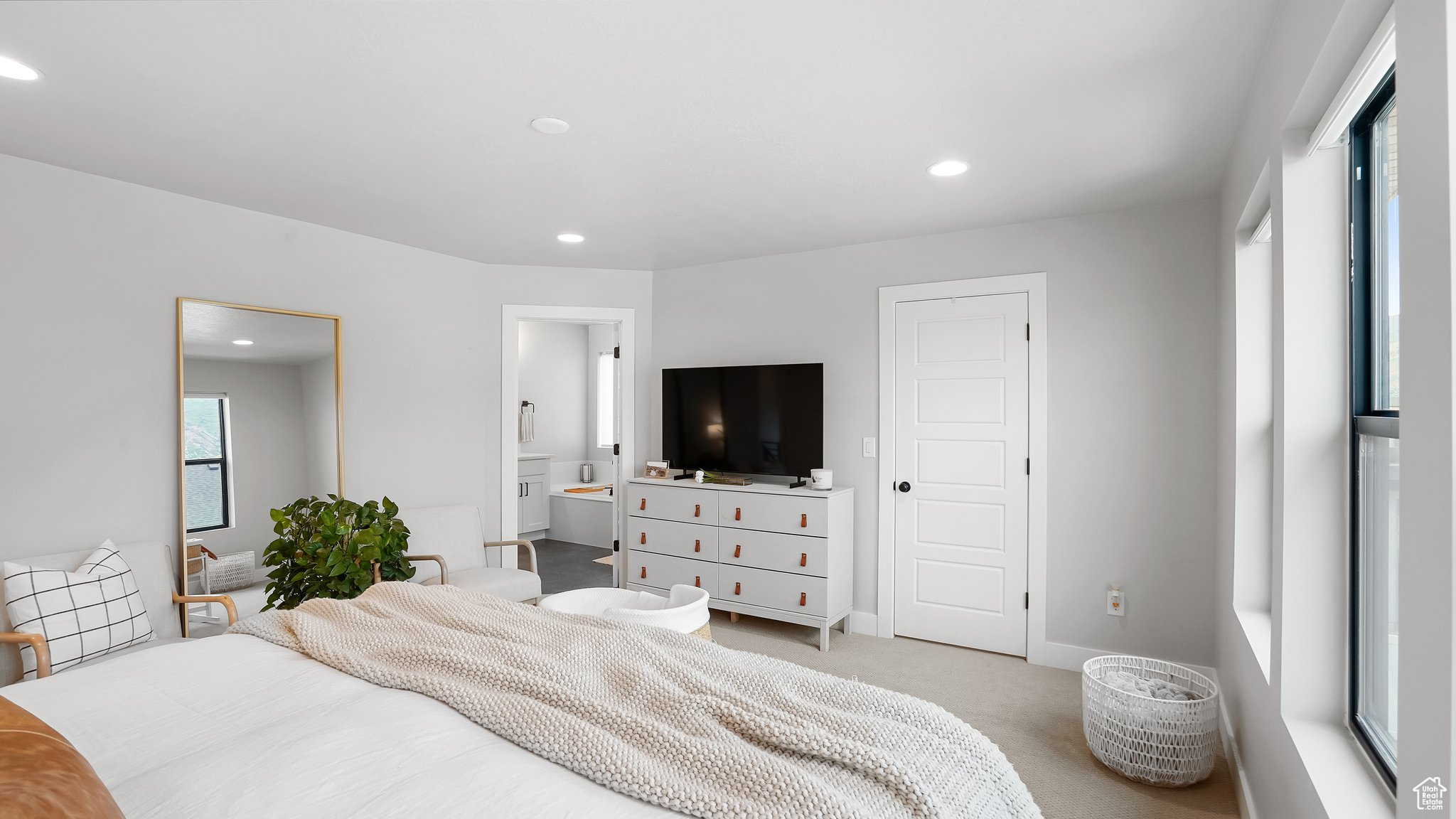 Bedroom with light colored carpet and ensuite bath