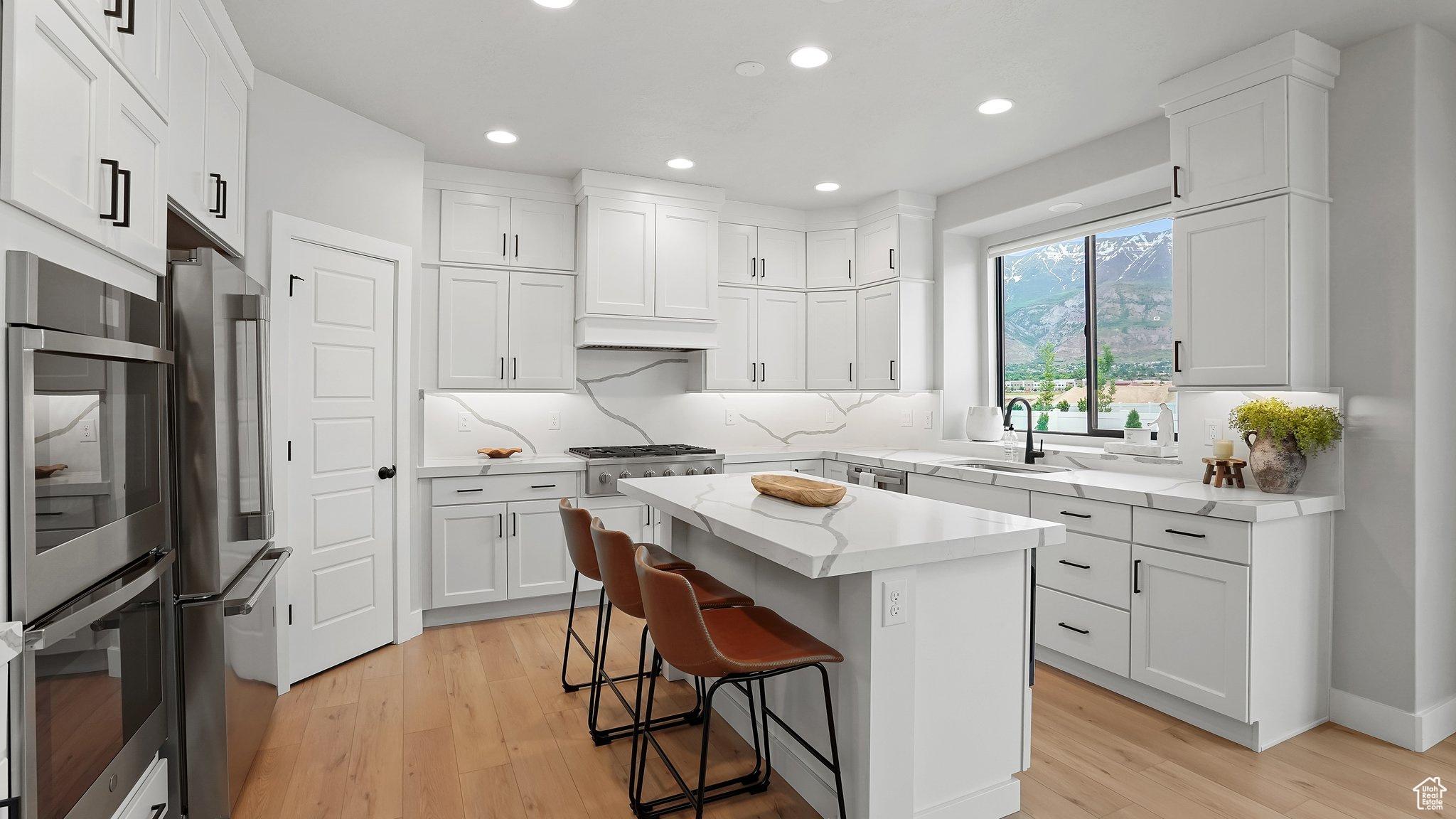 Kitchen featuring a center island, sink, light hardwood / wood-style flooring, and white cabinets