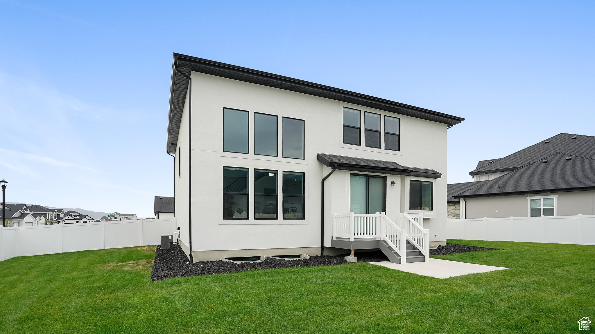 Rear view of property featuring central air condition unit and a lawn